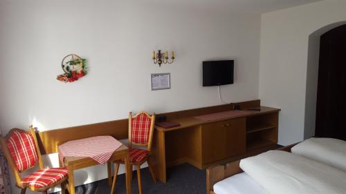 a hotel room with a desk and a bed and a room at Hotel Garni in Warth am Arlberg