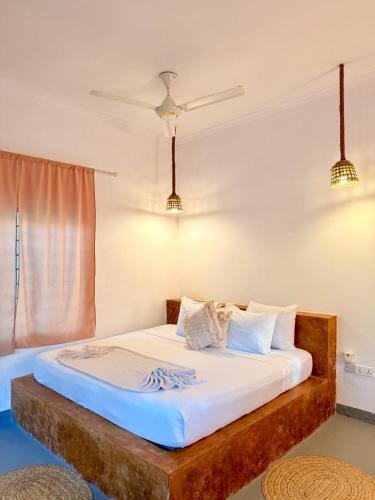a bed with white sheets and pillows in a room at Karanga Bungalows in Michamvi
