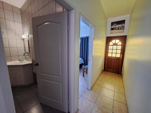 an open door to a bathroom with a sink at Das Moven Haus in Swakopmund