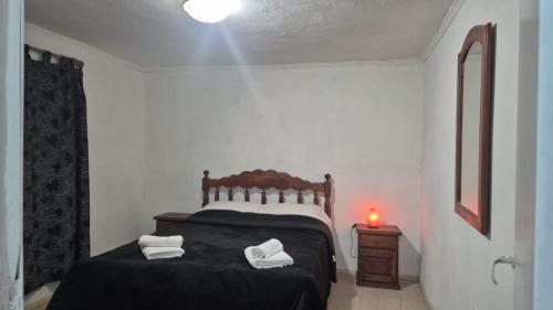 a bedroom with a bed with two white towels on it at Complejo Casablanca Plottier in Plottier