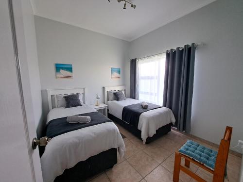 a bedroom with two beds and a window at Das Moven Haus in Swakopmund