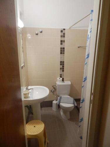 a small bathroom with a toilet and a sink at Angelo Apartments Tolo in Tolo