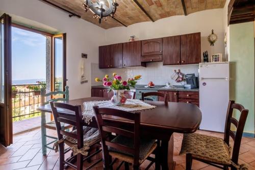 eine Küche mit Tisch und Stühlen und eine Küche mit Kühlschrank in der Unterkunft le stanze della Terrazza sul Borgo in Castel del Piano