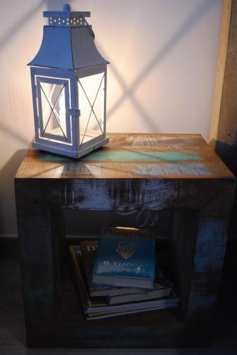 a lantern sitting on top of a table with books at Festina Lente B&B in Porto Recanati