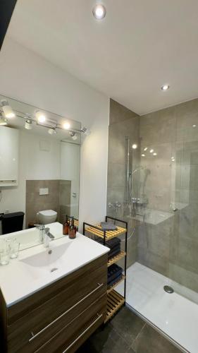 a bathroom with a sink and a shower and a tub at SCHILLING stay&more in Wörgl