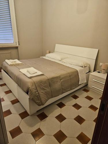 een slaapkamer met een groot bed en een tegelvloer bij Appartamento vicino lo stadio con garage in Piacenza