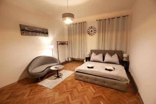 a bedroom with a bed and a chair in it at Naschpark Dream Apartments! in Vienna