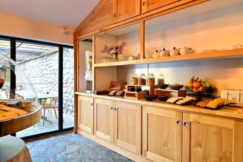 a kitchen with wooden cabinets and food on display at Hotel Restaurant & Spa E Caselle in Venaco