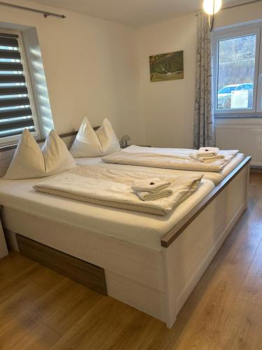 a large white bed in a room with a window at Seerestaurant & Suiten Hayat in Steindorf am Ossiacher See