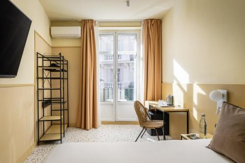 a bedroom with a bed and a desk and a window at BYPILLOW The Citadel in Madrid