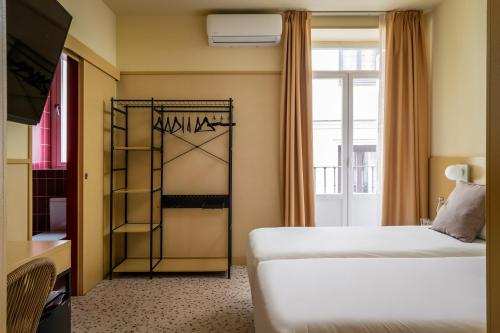 a hotel room with two beds and a window at BYPILLOW The Citadel in Madrid