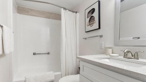 a white bathroom with a sink and a toilet at Landing Apartments - The Carlisle at Dunedin in Dunedin