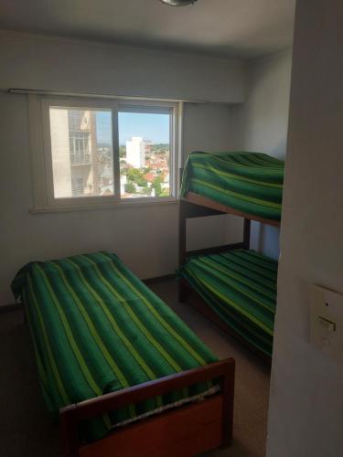 twee stapelbedden in een kamer met een raam bij La amistad in Necochea