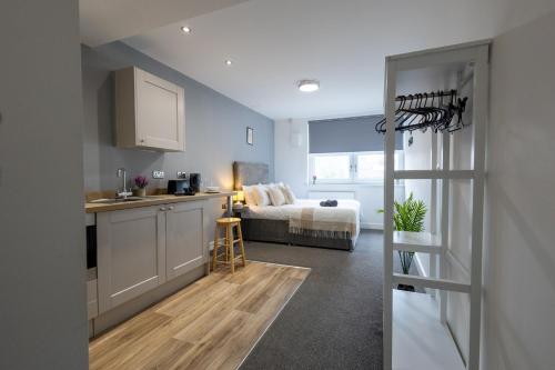 a kitchen and a bedroom with a bed in a room at Derwent Court Aparthotel in Derby