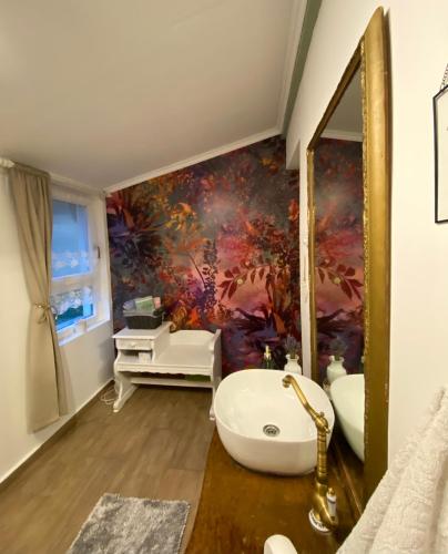 a bathroom with a large painting on the wall at Somlói Provence in Doba