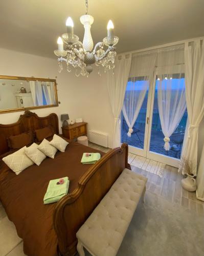 a bedroom with a large bed and a chandelier at Somlói Provence in Doba