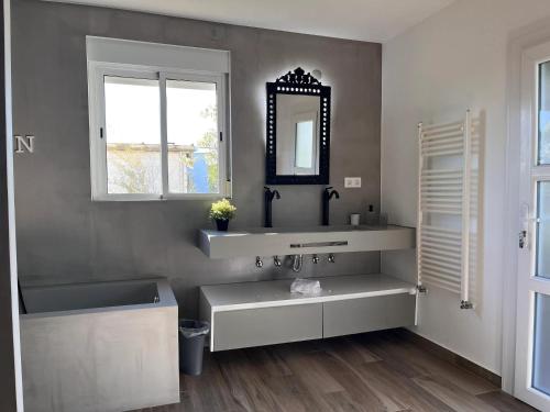 een badkamer met een wastafel en een spiegel bij House with Garden in Bombarral - 100 m², Shared Pool in Barrocalvo