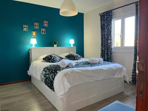 een slaapkamer met een wit bed en blauwe muren bij House with Garden in Bombarral - 100 m², Shared Pool in Barrocalvo