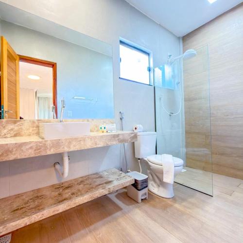 a bathroom with a sink and a shower and a toilet at Jangadeiro Praia Hotel Resort - Parque Aquático e Pé na Areia in Aquiraz