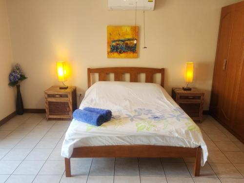 a bedroom with a bed with two night stands and two lamps at Villa Baansiesom in Sam Roi Yot