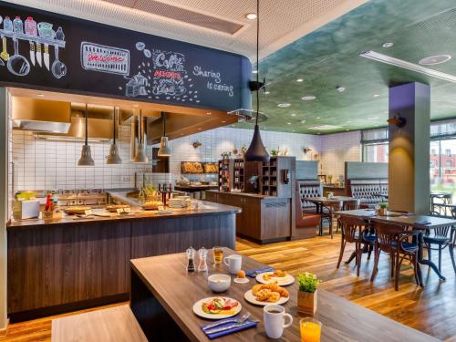 een restaurant met een tafel met eten erop bij ibis Styles Hamburg Barmbek in Hamburg