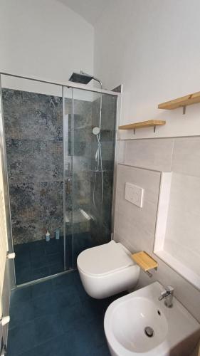 een badkamer met een douche, een toilet en een wastafel bij casa34 in Turijn