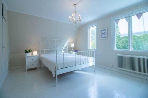una camera da letto bianca con un letto e un lampadario di JON830-Mariannelund-Hornsved-1 a Ingatorp