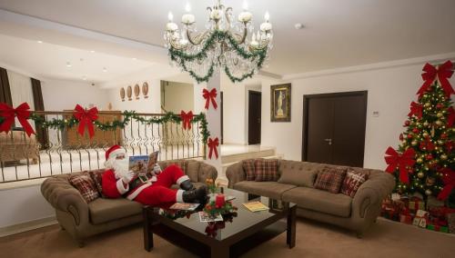 una stanza natalizia con un Babbo Natale sdraiato su un divano di Da Vinci Boutique Hotel a Baku