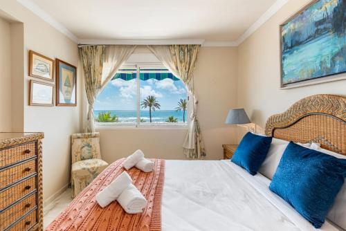 a bedroom with a bed and a window with the ocean at RgHost-Apartamento España en Paseo Marítimo in Málaga