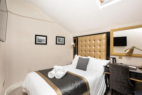 een hotelkamer met een bed met handdoeken erop bij Museum Residence Oxford in Oxford