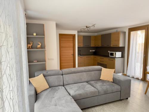 a living room with a couch and a kitchen at Chalet Ski Home - Madesimo in Madesimo