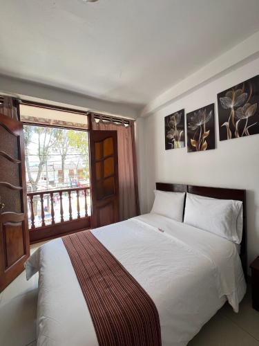 a bedroom with a white bed and a window at Tintaya Hotel Chachapoyas in Chachapoyas