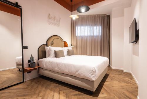 a bedroom with a large bed and a mirror at Jrose Hotel in Jerusalem