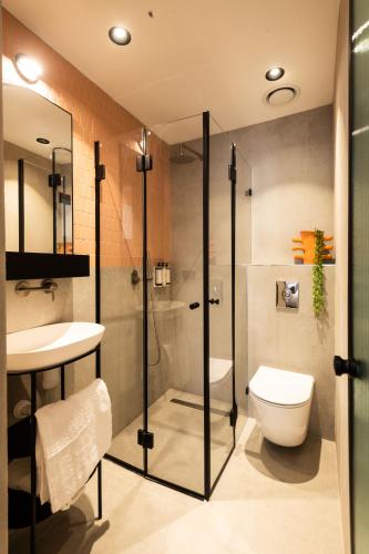 a bathroom with a shower and a toilet and a sink at Jrose Hotel in Jerusalem