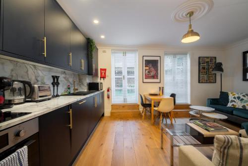 a kitchen and living room with a couch and a table at 3 Bedroom 2 Bath Serviced Apartment, Hackney & Shoreditch, Sleeps 8 in London