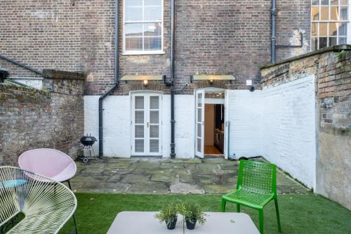 a patio with a green chair and a table at 3 Bedroom 2 Bath Serviced Apartment, Hackney & Shoreditch, Sleeps 8 in London