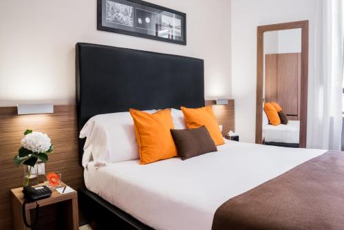 a bedroom with a large bed with orange pillows at Hotel Concordia in Rome