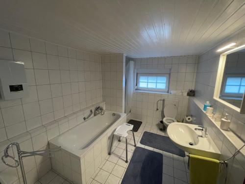 a bathroom with a tub and a sink and a toilet at Ferienwohnung I&I in Halsenbach