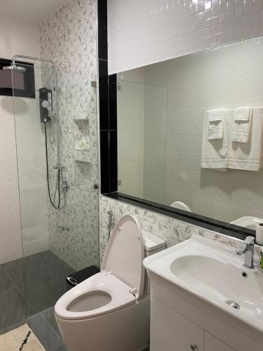 a bathroom with a toilet and a sink and a mirror at Alayah บ้านเดี่ยวสองชั้น ธาดาดิโอเอซิส in Ban Krok Khi Nu
