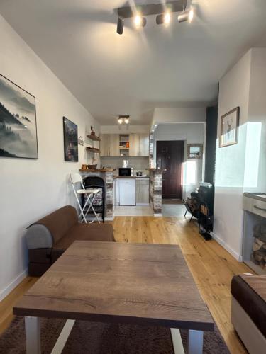 een woonkamer met een tafel en een keuken bij Apartman D&D Šišava Vlašić in Vlasic