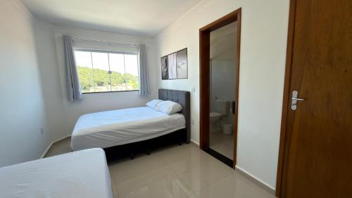 En eller flere senge i et værelse på Casa tipo apartamento aconchegante a 3 minutos do Centro e Parque das Águas com vista para as montanhas