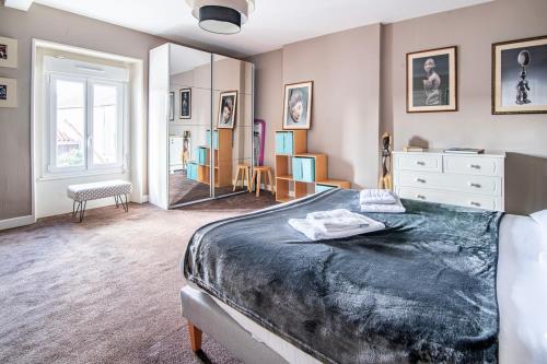 a bedroom with a large bed and a mirror at Le Vincennes, simple et atypique ! in Cholet