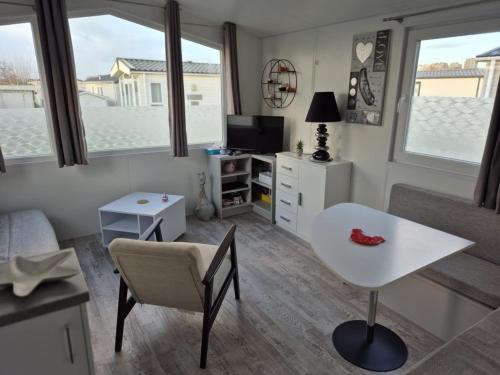 a small living room with a table and a desk at Dans le vent in Middelkerke