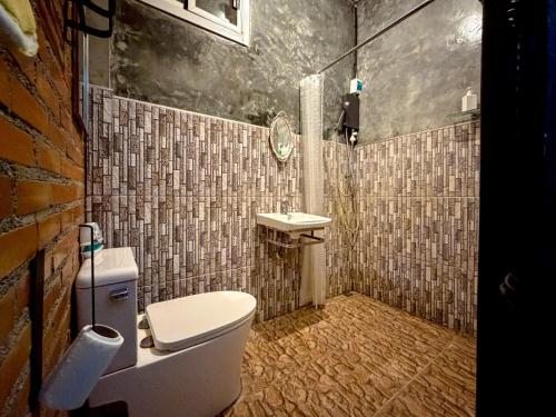 un bagno con un water e un lavandino di วีรพัชนารา a Ban Musoe