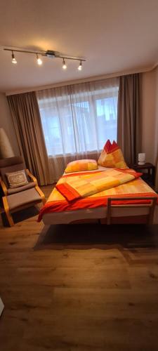 een slaapkamer met een groot bed voor een raam bij Ferienwohnung Huber in Söll