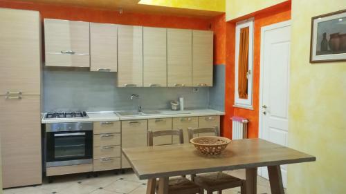 een keuken met een tafel, een wastafel en een fornuis bij Happy Home Apartament in Arezzo