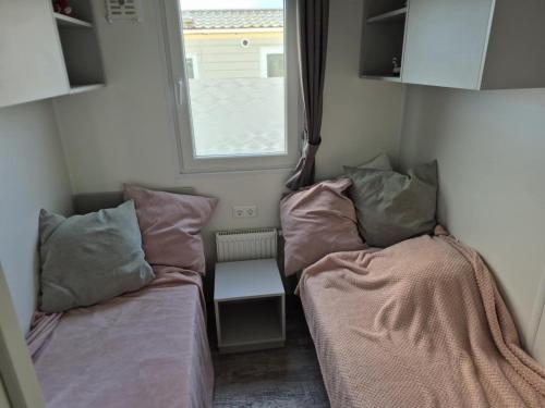 a small room with two beds and a window at Dans le vent in Middelkerke
