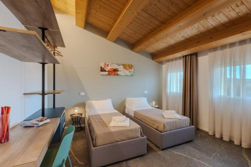 a hotel room with two beds and a desk at Villa Alice in Montecosaro
