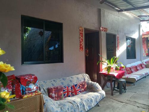 ein Wohnzimmer mit Sofas und einem Tisch mit Tisch in der Unterkunft Daisy Food House and Inn in Maria