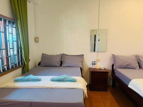 een slaapkamer met twee bedden, een tafel en een raam bij Easy Home Koh Rong in Kaôh Rŭng (3)